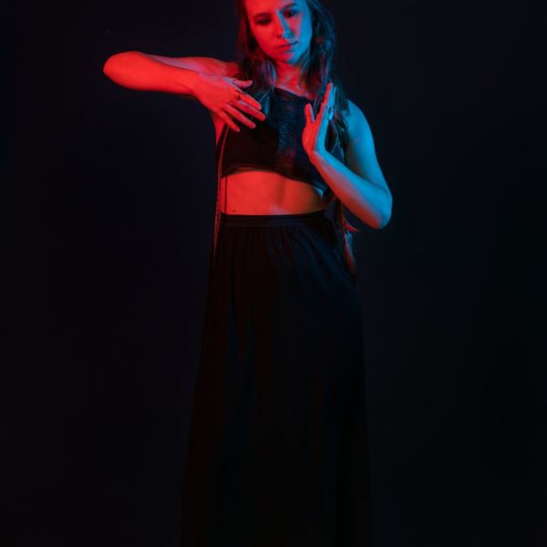 Person doing a powerful yoga pose against a dark, minimalist background.